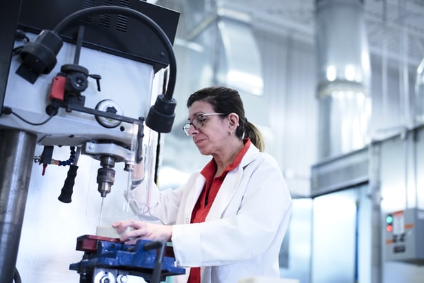 Femme qui imprime une pièce en ULTEM. 